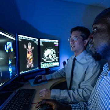 Section chief of Nuclear Medicine and radiologist Phillip Kuo, M.D., looking at PET scans