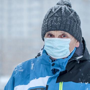 image of a person wearing a parka and a face mask in snowy weather