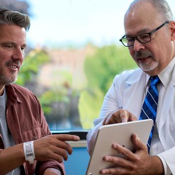 image of a doctor showing something on a laptop to a patient