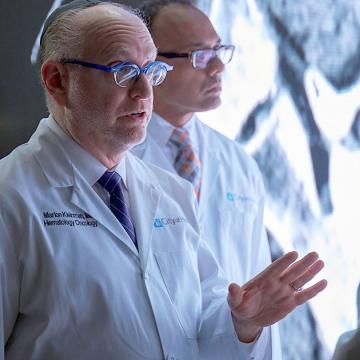 image of a doctor talking to another doctor with a third in the background