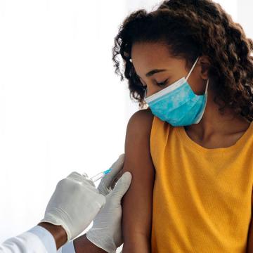 image of a doctor vaccinating a child being held by a woman