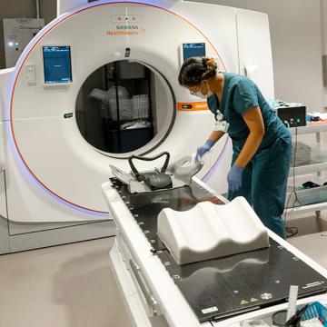 image of a woman in scrubs prepping an MRI machine