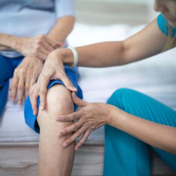 image of a doctor feeling a patient's knee