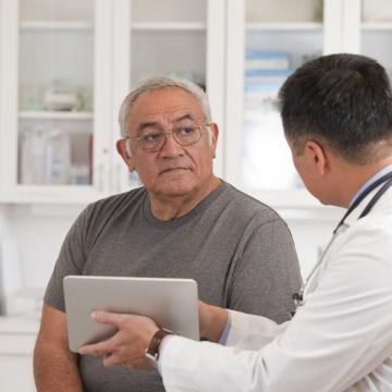 image of a doctor showing the screen of a small laptop to an older man