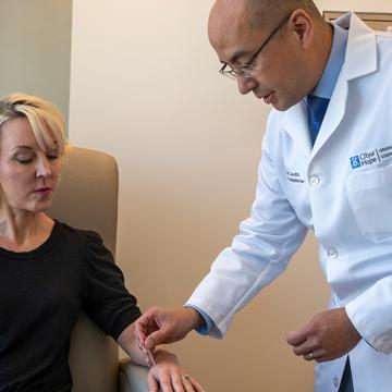 Richard Lee, M.D., performing acupuncture on patient