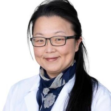 Female doctor headshot in white lab coat