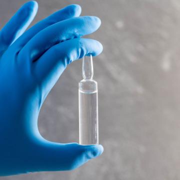 vial of chemotherapy treatment held in gloved hand