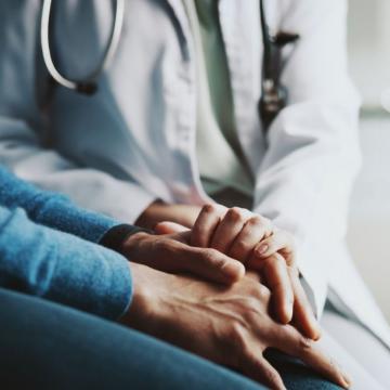 Physician holding hands and comforting a patient