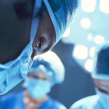 Masked surgeon performing surgery