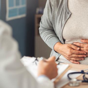 Female patient holding her stomach at a doctor's appointment