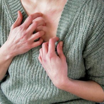 Woman scratching her chest with her hand