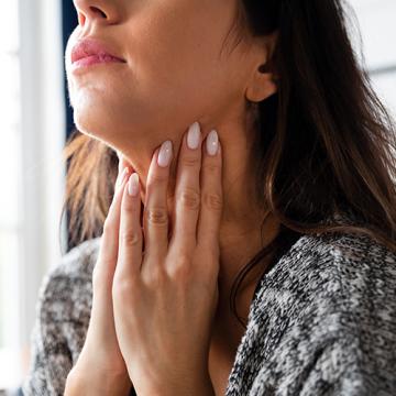 Person examining their thyroid area