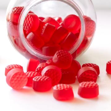 A bottle of red dyed supplements spilled over