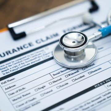 A stethoscope sitting on top of an insurance claim form 
