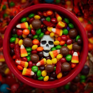 A bowl of Halloween candy with a candy skull in the middle