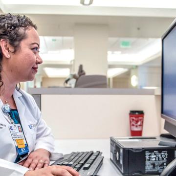Nurse looking at computer screen 1024x475