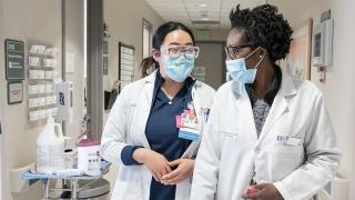 Two healthcare workers walking down a hallway