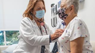 A care provider uses a stethoscope on a patient