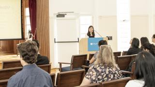 Student presenting nutrition research to a group of audience at the Houe of Hope