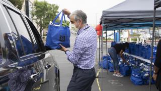 City of Hope doctor giving a bag of produce to patients.