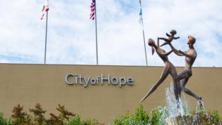 Campus view with the Spirit of Life fountain, depicting two parents lifting a child with joy