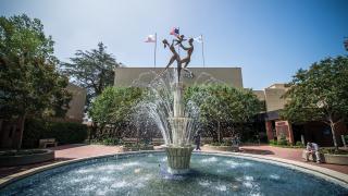 A photo of a fountain in front of the City of Hope building.