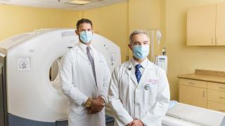 Two doctors standing by a treatment device with confidence