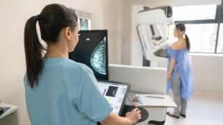  Nurse giving a mammogram exam to an adult patient at the hospital