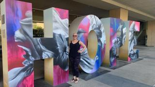 Imelda Jordan posing in front of a sculpture of Hope