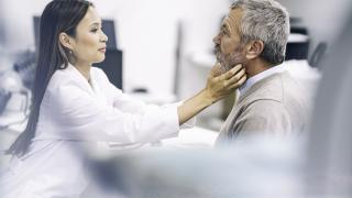 Doctor examining patient's neck