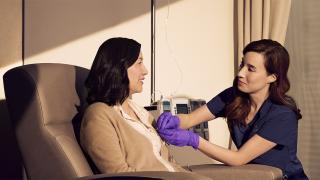 Patient smiles as she discusses with the nurse sitting beside her.