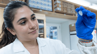 A researcher holds a lab sample at City of Hope