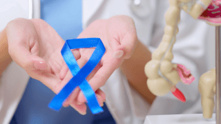 A nurse holds a colon cancer ribbon