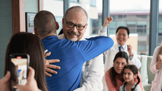 A City of Hope cancer expert hugs a patient