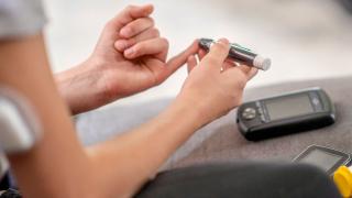 image of a person using an insulin tester