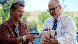 image of a doctor showing something on a laptop to a patient
