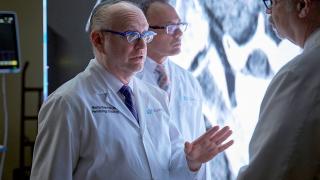 image of a doctor talking to another doctor with a third in the background