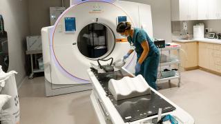 image of a woman in scrubs prepping an MRI machine