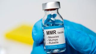 image of a measles, mumps and rubella vaccine bottle held in a blue gloved hand