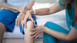 image of a doctor feeling a patient's knee