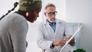 image of a doctor explaining a chart to a woman in the foreground