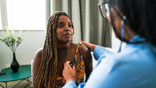 central image of a black woman with a doctor in the foreground
