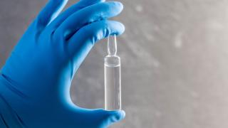 vial of chemotherapy treatment held in gloved hand