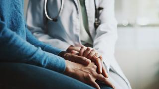 Physician holding hands and comforting a patient