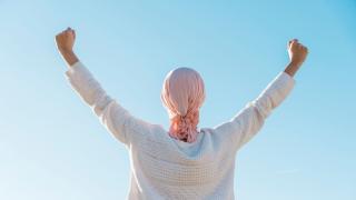 Cancer patient celebrating remission with arms in the air