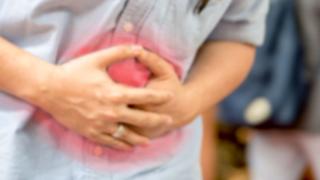 Person holding their stomach in pain