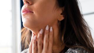 Person examining their thyroid area