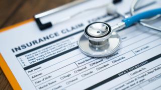 A stethoscope sitting on top of an insurance claim form 