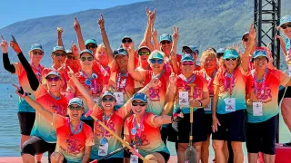 Los Angeles Pink Dragons team posing with medals and paddles at a dragon boat event