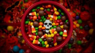 A bowl of Halloween candy with a candy skull in the middle